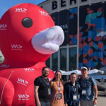 clickstorm beim WeAreDevelopers World Congress in berlin 2024: 4 Kollegen vor eine riesigien roten Gummi-Ente mit den WWC Logo